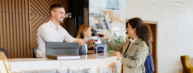 receptionist tager imod gæst på hotel